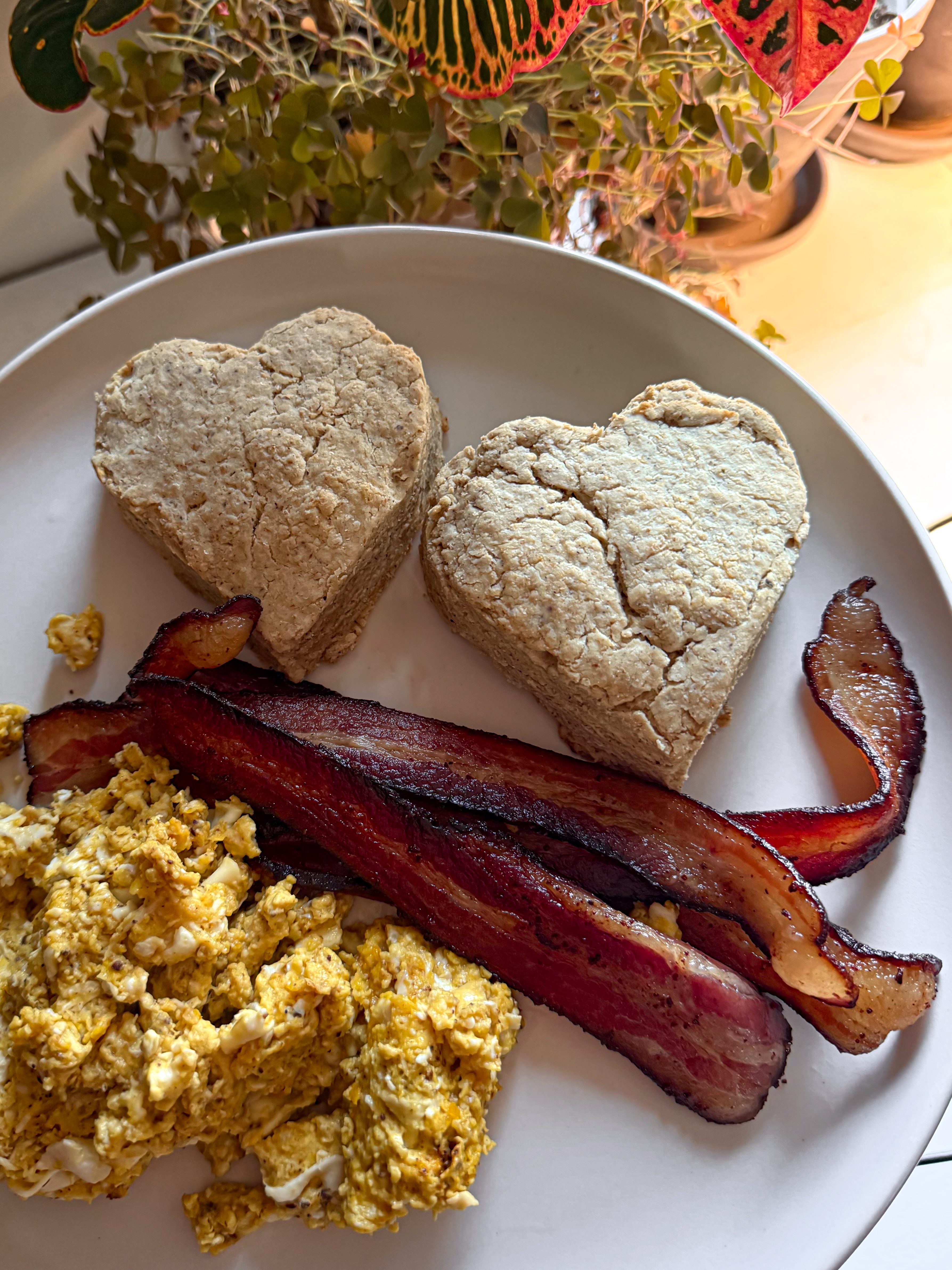 Warm skillet biscuits, scrambled eggs, and crispy bacon served on a plate