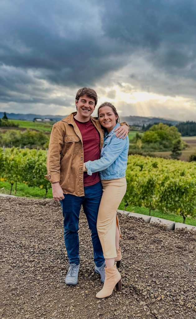 A couple standing together on a scenic hillside, representing the heart of Fiddlehead Homestead.